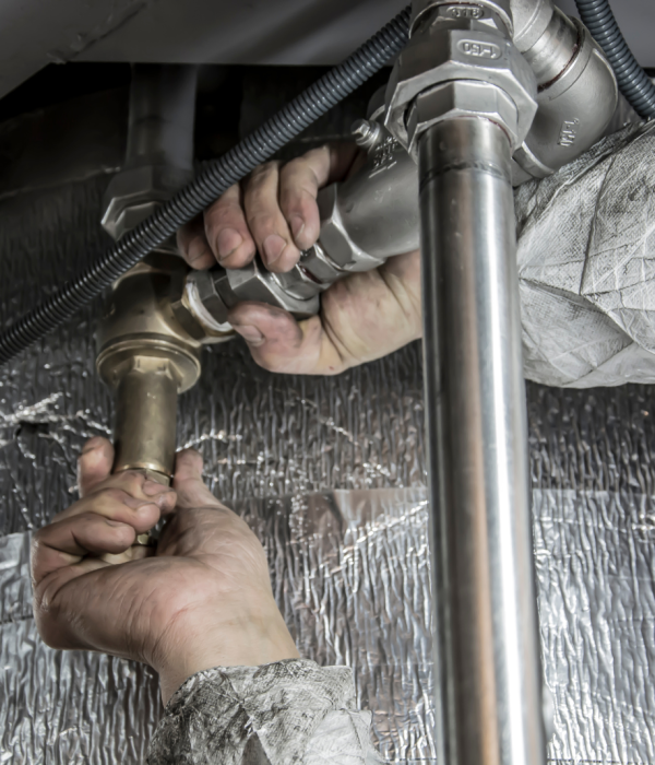 man hands tighting down pipes